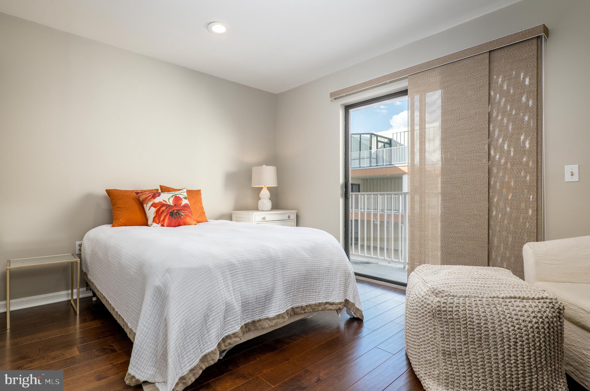 2702 Lighthouse Point East, Unit 637 Baltimore, MD 21224 - Photo 25 of 37 a bedroom with a bed and wooden floor