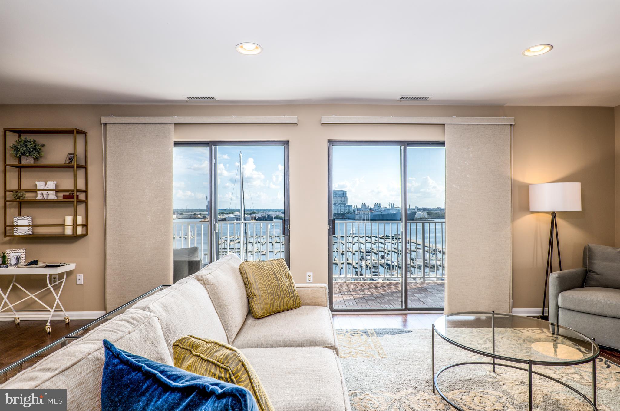 2702 Lighthouse Point East, Unit 637 Baltimore, MD 21224 - Photo 4 of 37 a living room with furniture and a window