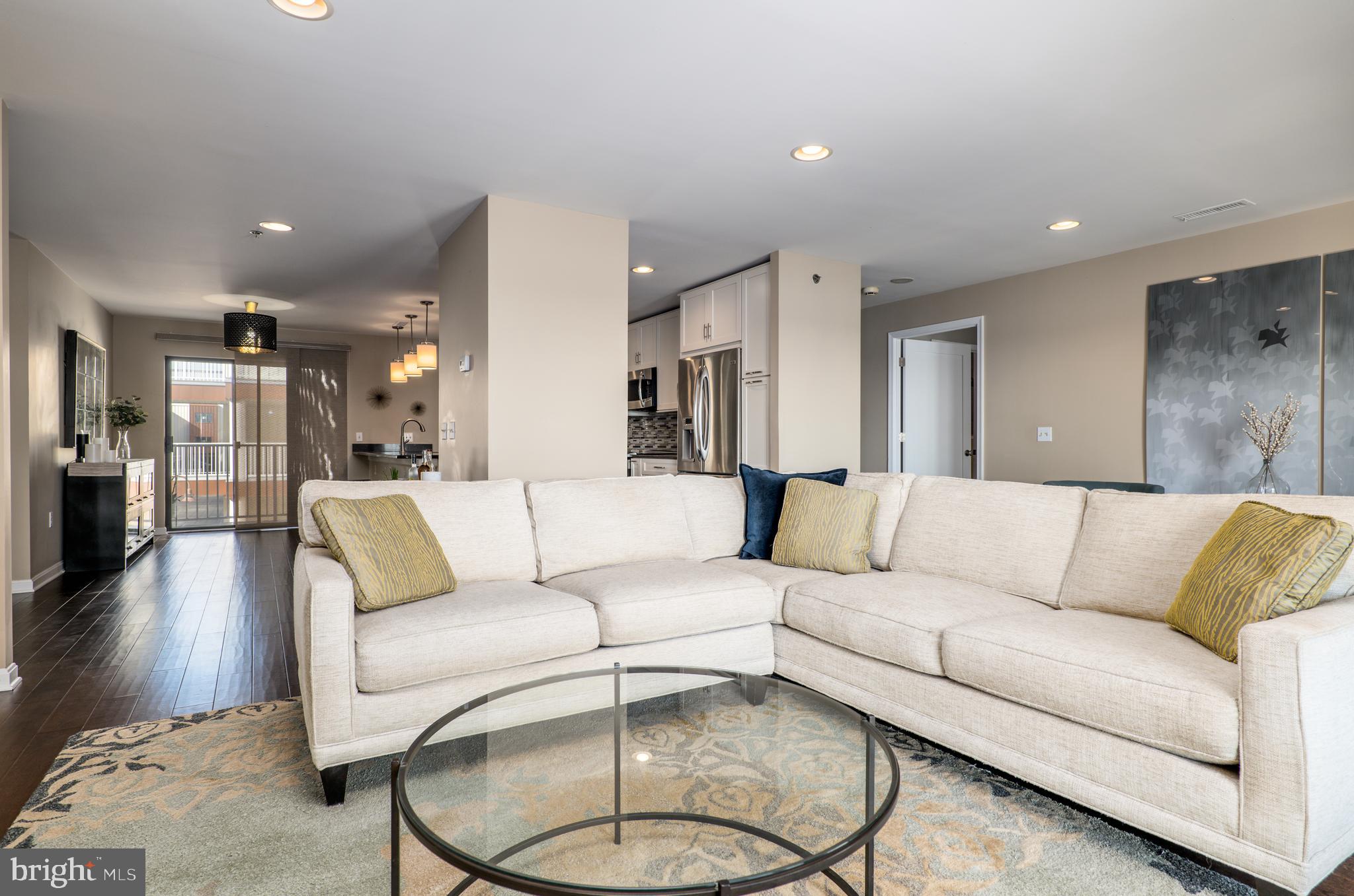 2702 Lighthouse Point East, Unit 637 Baltimore, MD 21224 - Photo 5 of 37 a living room with furniture and kitchen view