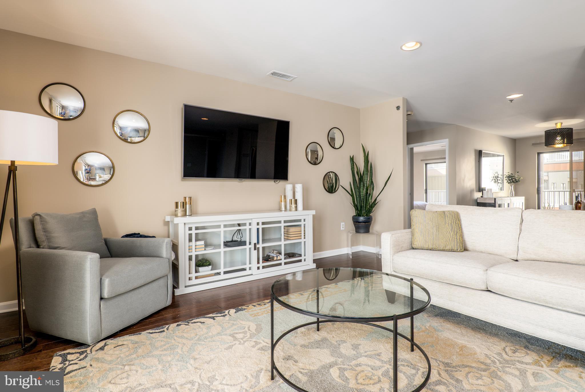 2702 Lighthouse Point East, Unit 637 Baltimore, MD 21224 - Photo 6 of 37 a living room with furniture and a flat screen tv