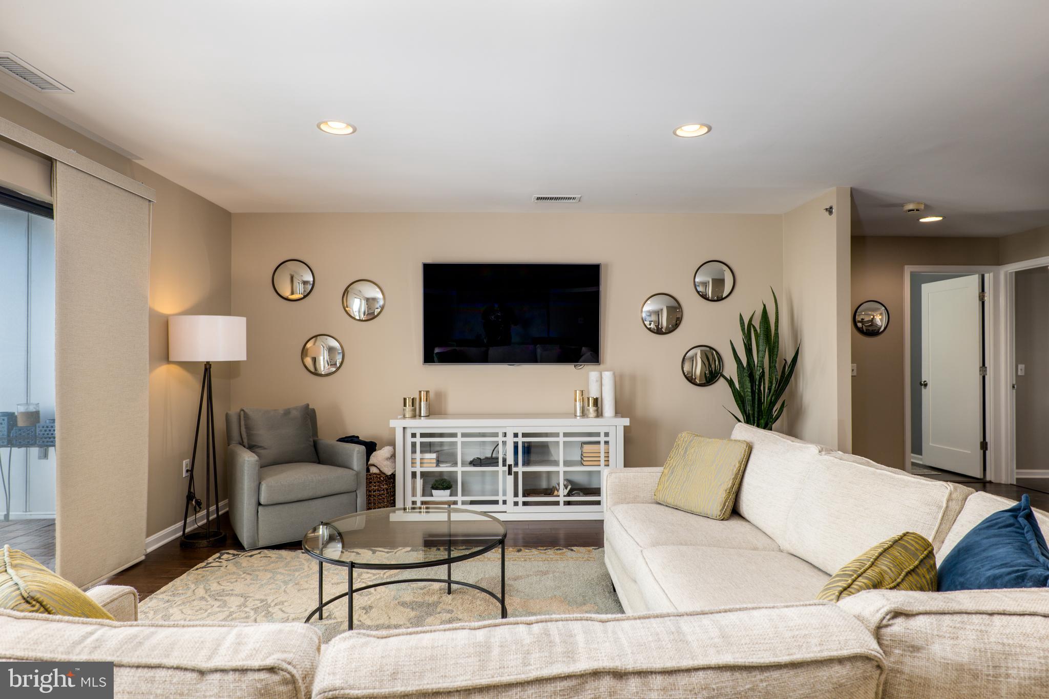 2702 Lighthouse Point East, Unit 637 Baltimore, MD 21224 - Photo 7 of 37 a living room with furniture and a flat screen tv