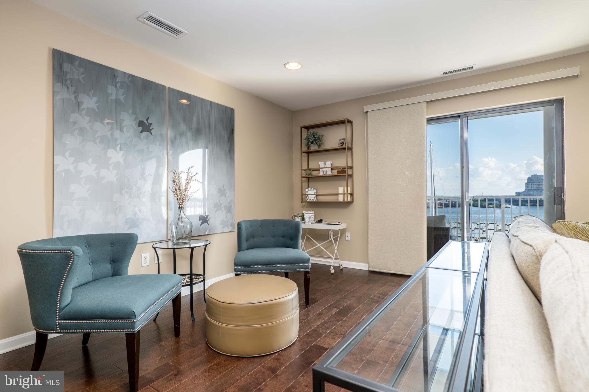 2702 Lighthouse Point East, Unit 637 Baltimore, MD 21224 - Photo 9 of 37 a living room with furniture and a large window