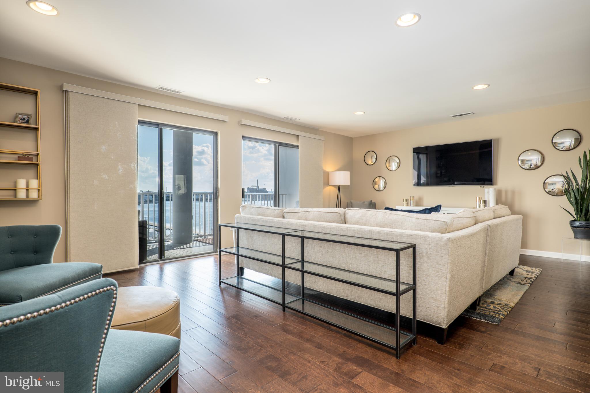 2702 Lighthouse Point East, Unit 637 Baltimore, MD 21224 - Photo 10 of 37 a living room with furniture and a flat screen tv