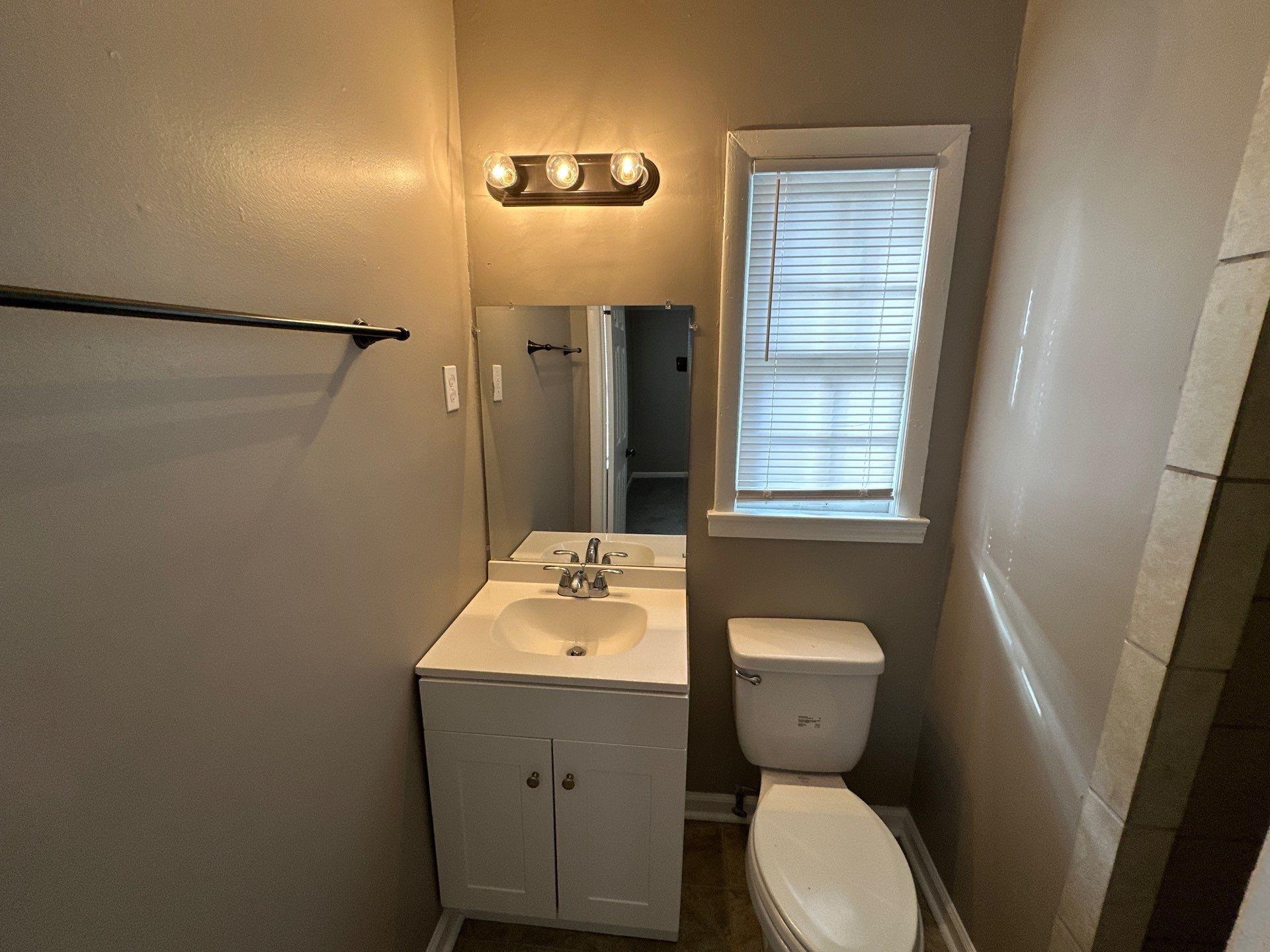 10 West Mitchell Road Memphis, TN 38109 - Photo 2 of 11 a bathroom with a toilet sink and mirror