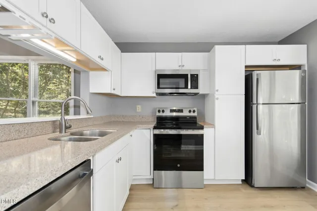 a kitchen with stainless steel appliances granite countertop a sink stove and microwave