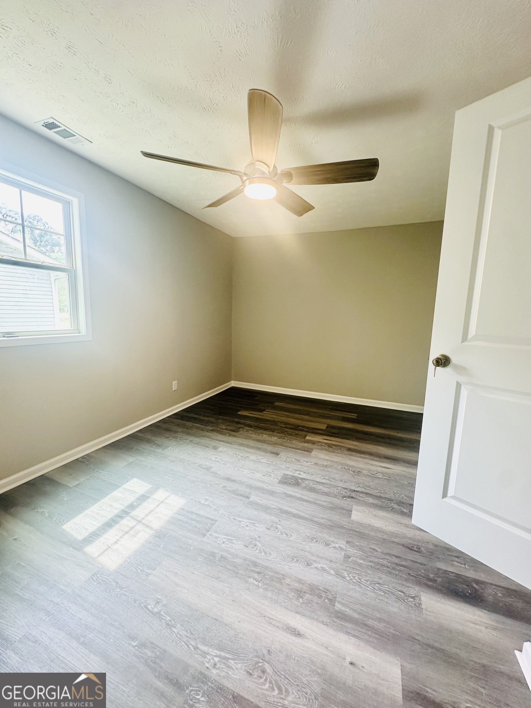 70 Darwin Drive Jonesboro, GA 30238 - Photo 12 of 19 a view of empty room with wooden floor and fan