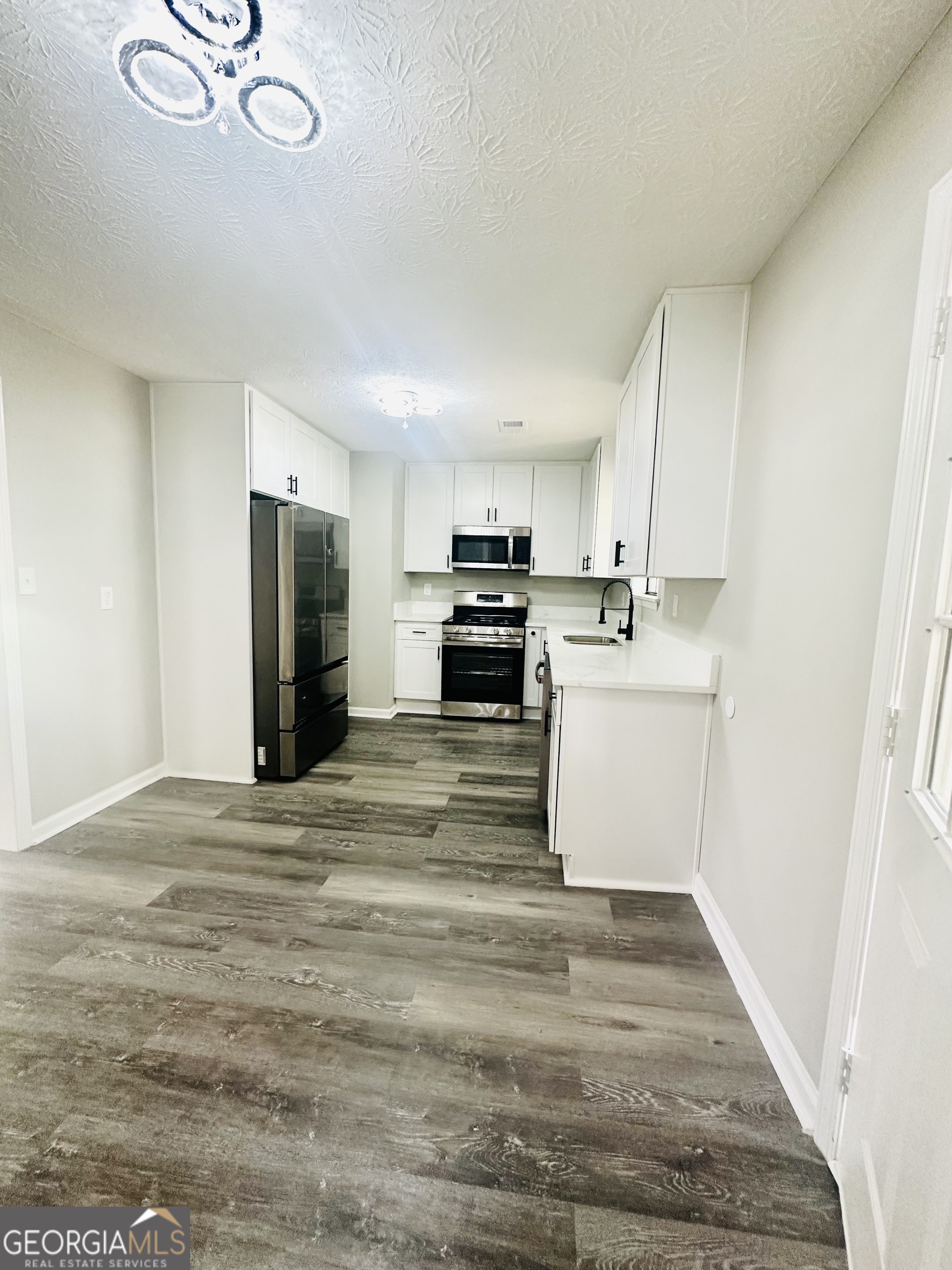 70 Darwin Drive Jonesboro, GA 30238 - Photo 9 of 19 a view of kitchen with stainless steel appliances granite countertop a stove a refrigerator a sink dishwasher and a refrigerator with wooden floor