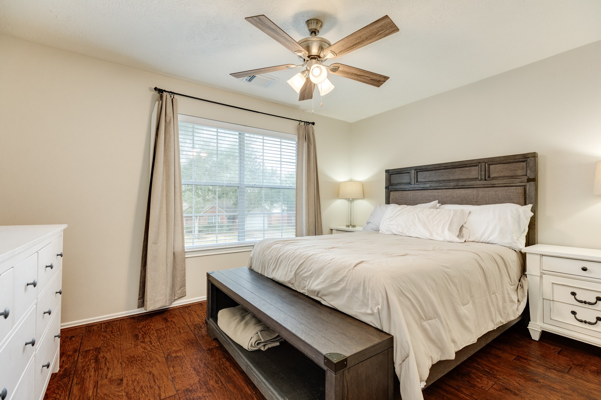 4113 Merlet Drive Pearland, TX 77584 - Photo 22 of 36 Bedroom one upstairs, facing the main road, features beautiful wooden floors, large windows, and is very spacious.