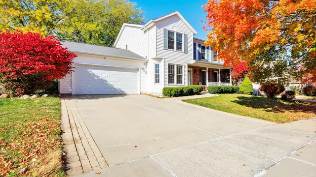 a front view of a house with a yard and trees