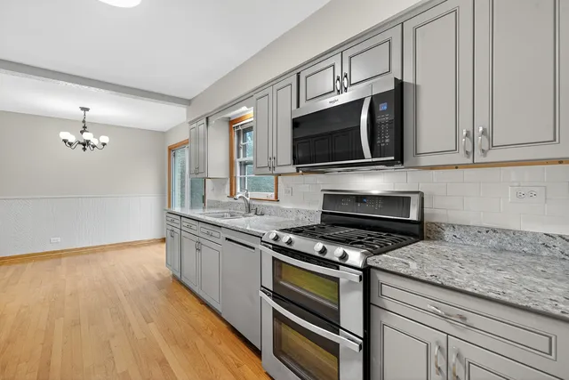 a kitchen with granite countertop a stove and a microwave