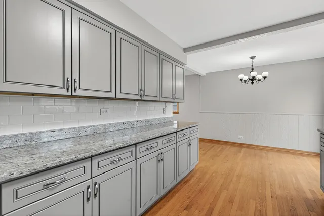 a kitchen with granite countertop wooden cabinets a sink and dishwasher