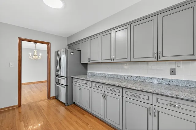 a kitchen with granite countertop white cabinets and stainless steel appliances