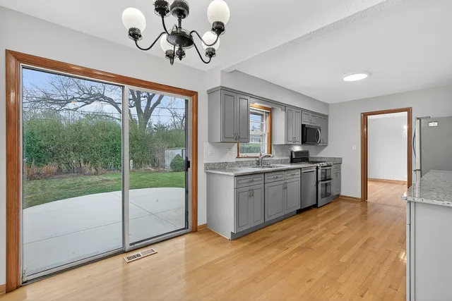 a kitchen with a refrigerator a stove top oven and a large window