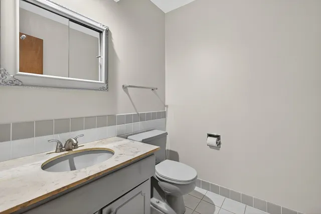 a bathroom with a granite countertop sink and a toilet