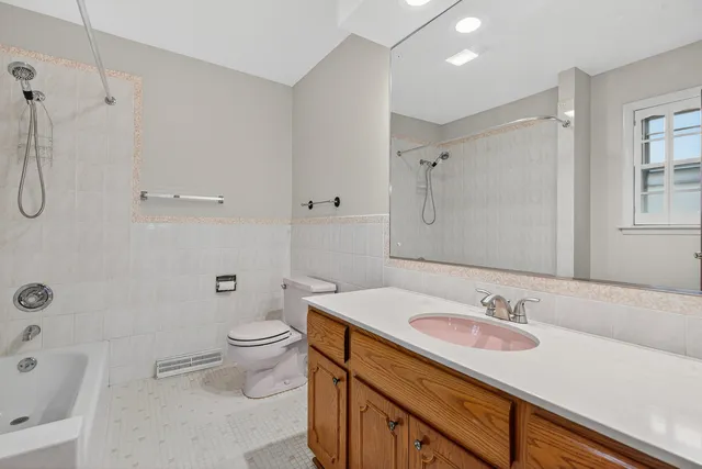a bathroom with a sink toilet vanity and shower