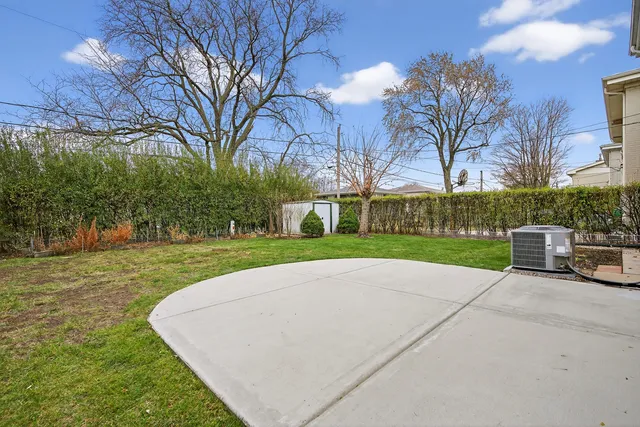 a view of a house with a big yard and large trees