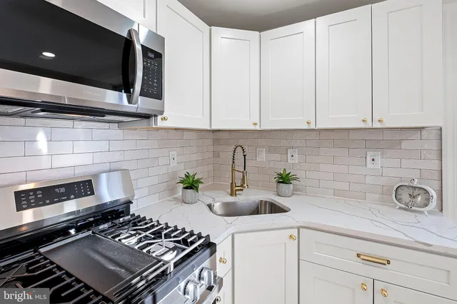 a kitchen with a stove a microwave and cabinets