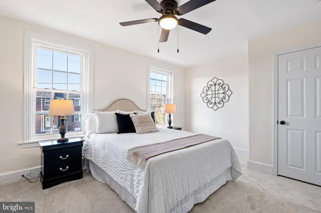 a bedroom with a bed and a lamp on dresser