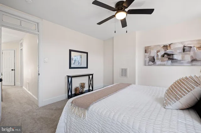 a bedroom with a bed and a painting on the wall