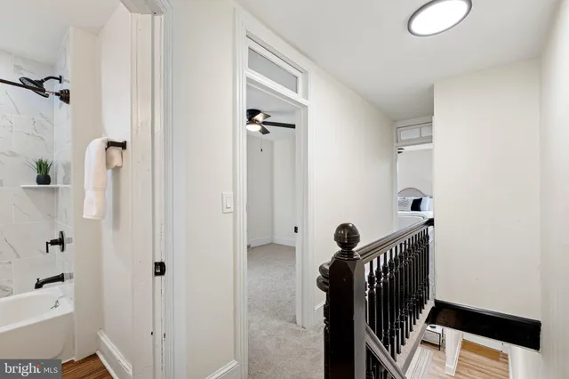 a view of a hallway with wooden floor and staircase