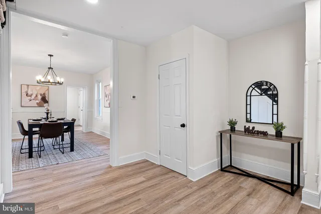 a view of a dining room with furniture a chandelier and wooden floor