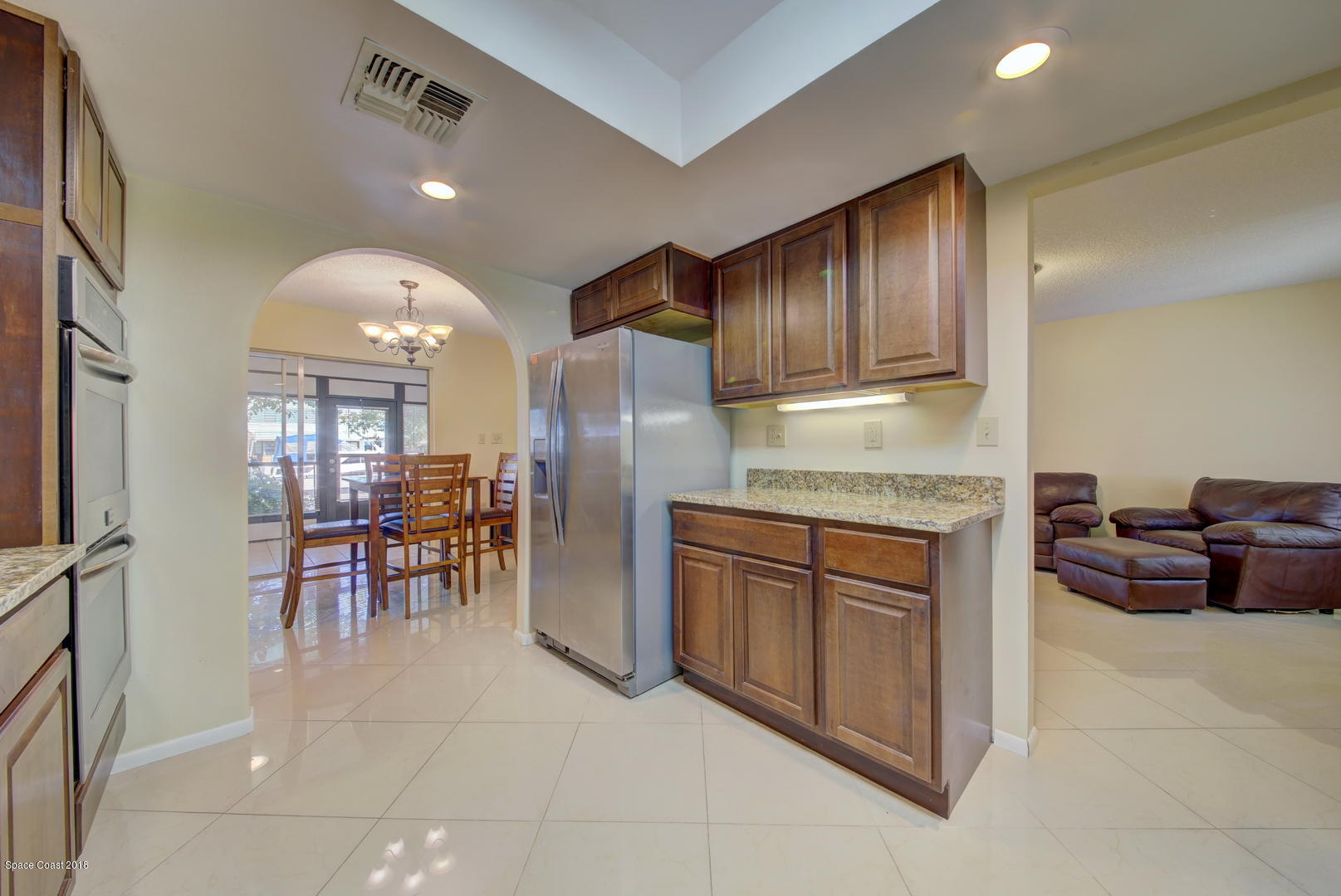 1005 Audubon Road Merritt Island, FL 32953 - Photo 12 of 39 a kitchen with granite countertop cabinets and refrigerator
