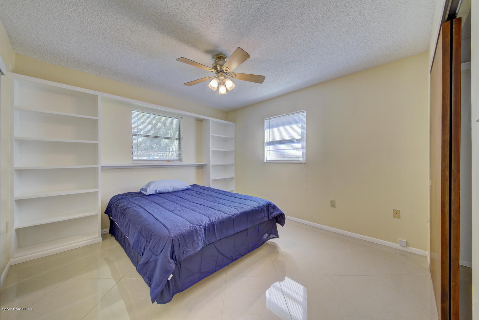 1005 Audubon Road Merritt Island, FL 32953 - Photo 16 of 39 a bedroom with a bed and a chandelier