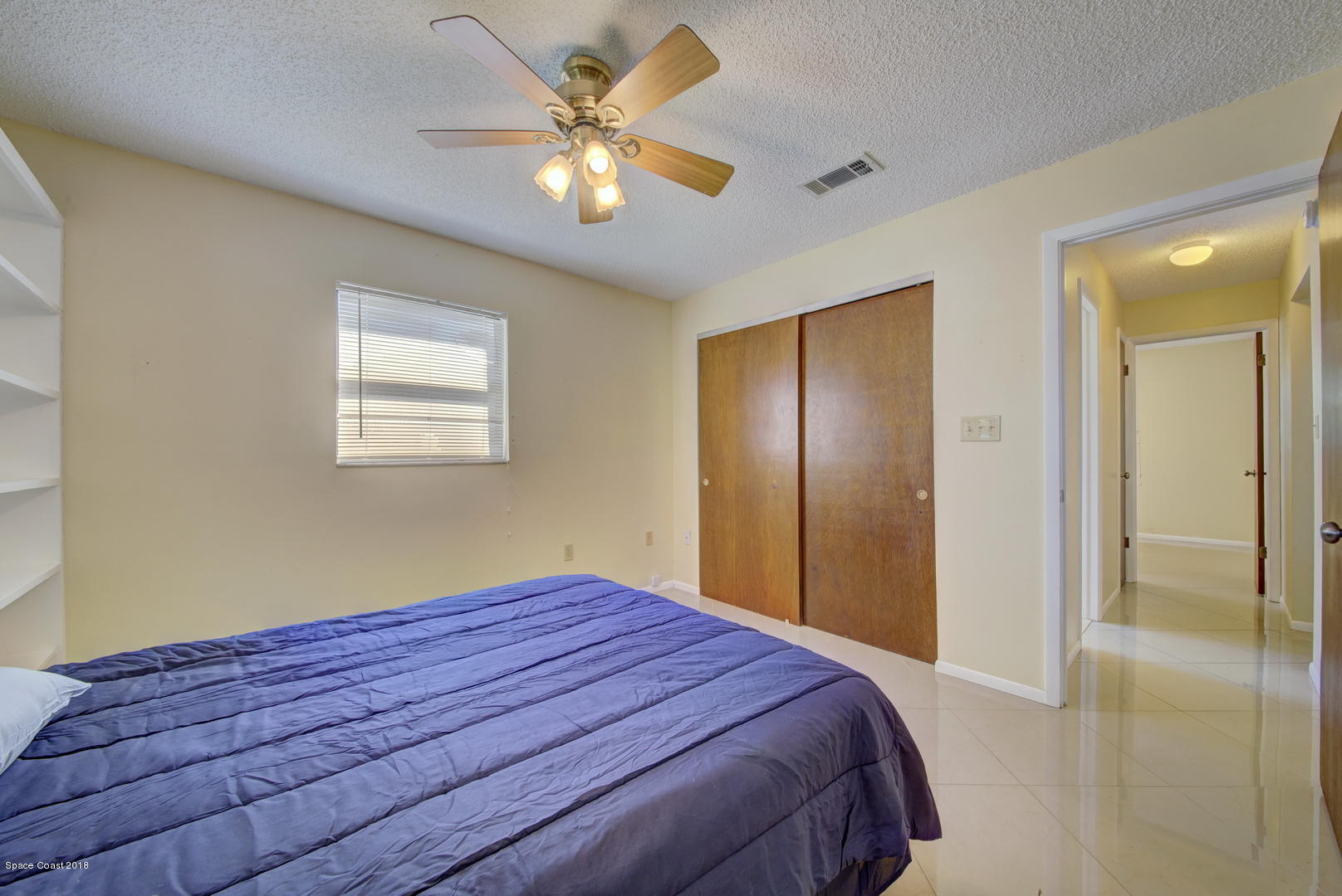1005 Audubon Road Merritt Island, FL 32953 - Photo 17 of 39 a bedroom with a bed and a chandelier