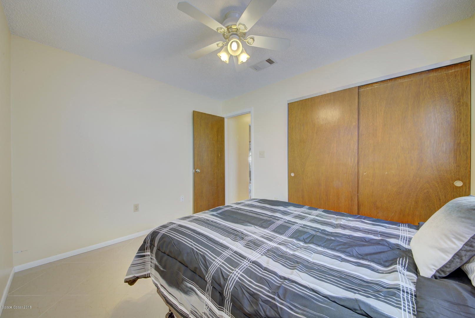 1005 Audubon Road Merritt Island, FL 32953 - Photo 21 of 39 a bedroom with a bed and a chandelier