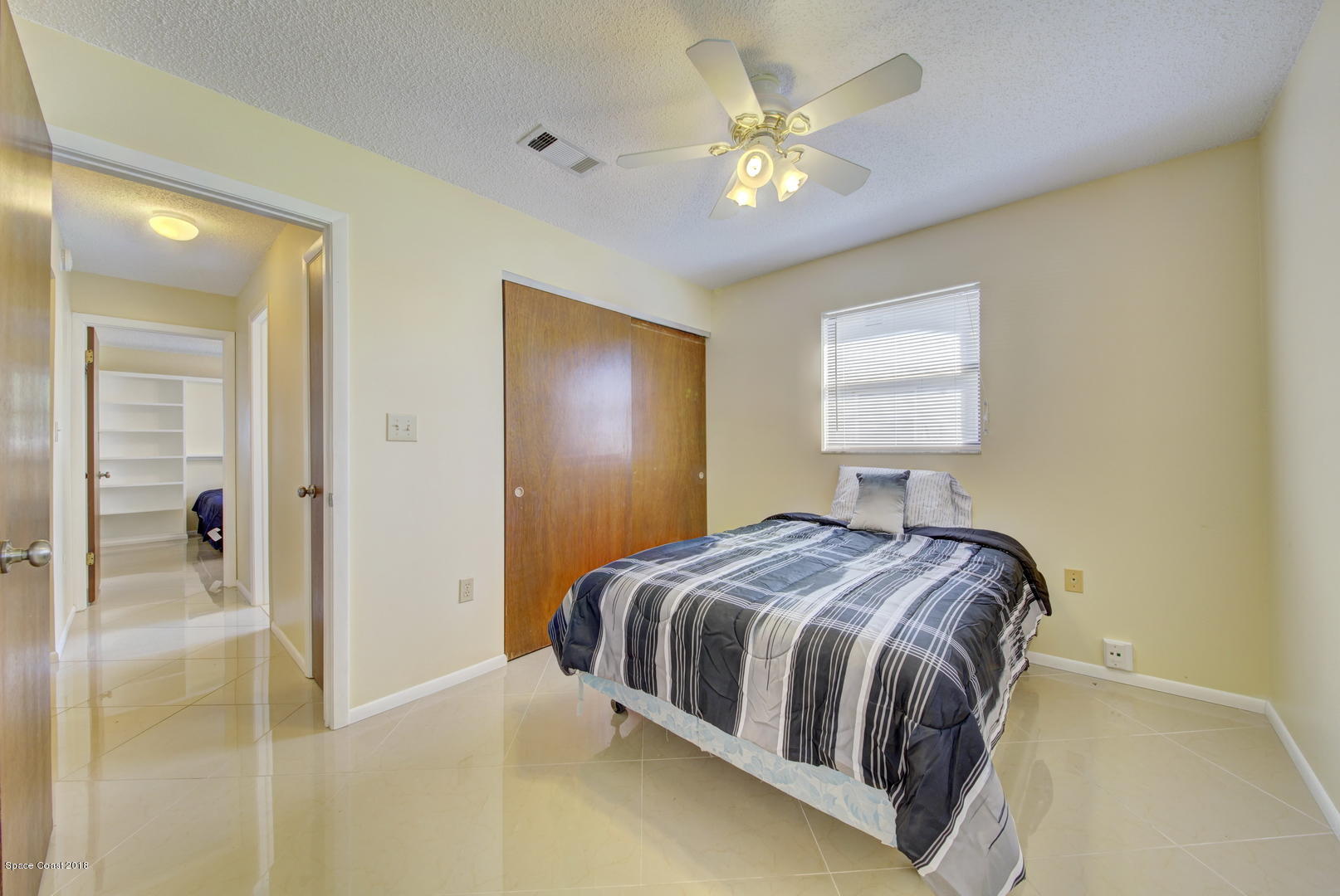 1005 Audubon Road Merritt Island, FL 32953 - Photo 22 of 39 a bedroom with a bed and a chandelier