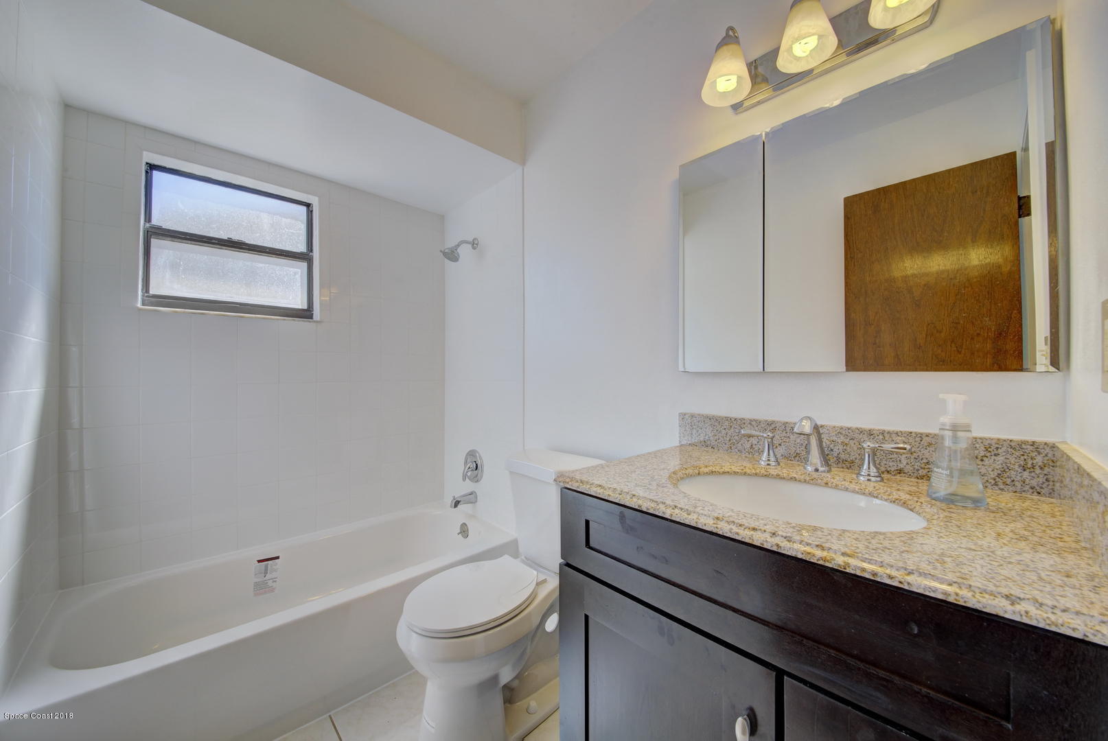 1005 Audubon Road Merritt Island, FL 32953 - Photo 25 of 39 a bathroom with a granite countertop sink a toilet a mirror and shower
