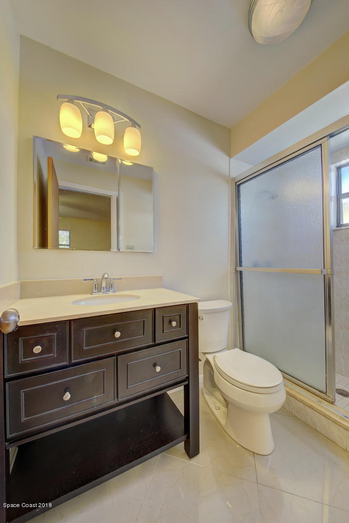 1005 Audubon Road Merritt Island, FL 32953 - Photo 27 of 39 a bathroom with a sink a toilet a mirror and a window