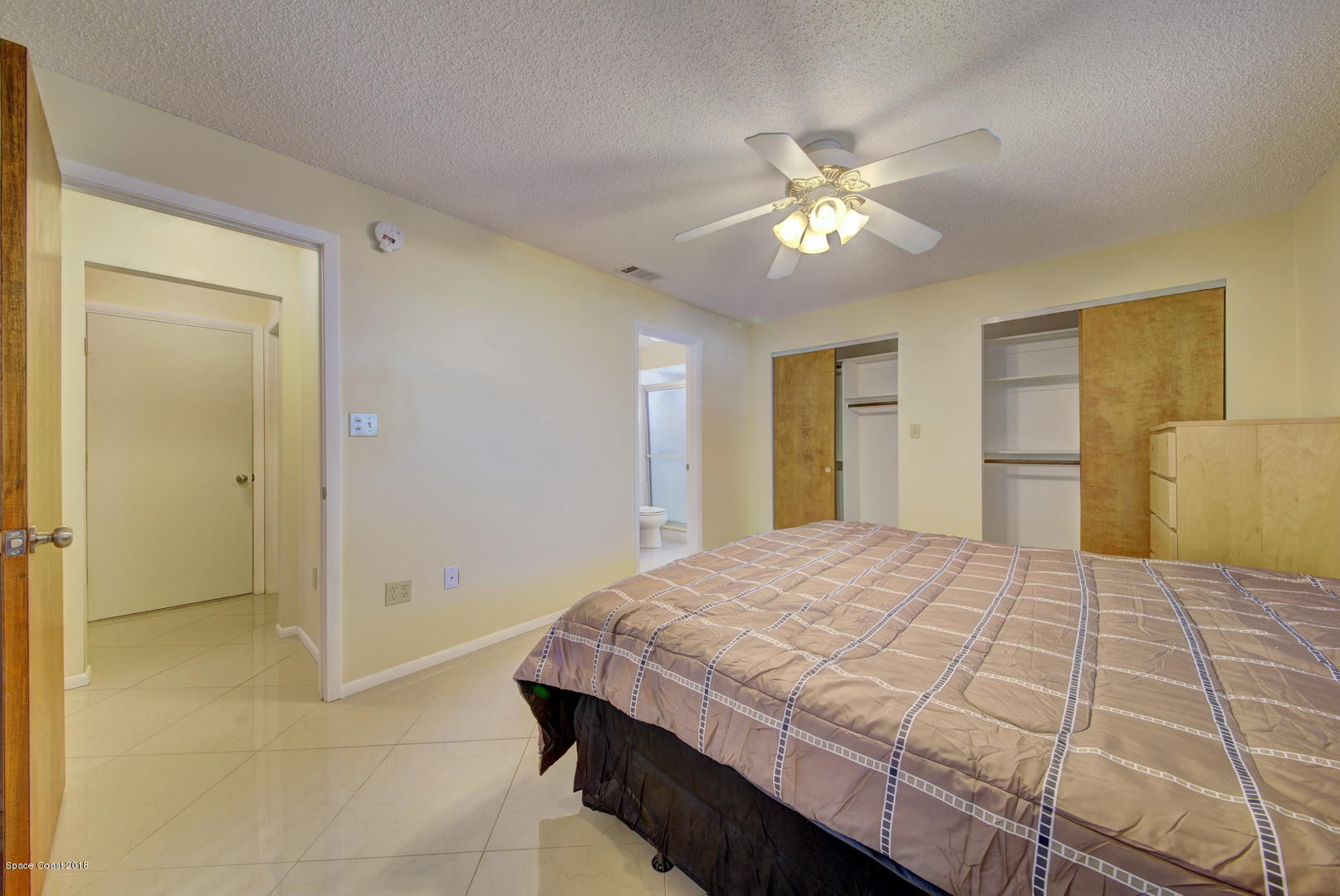1005 Audubon Road Merritt Island, FL 32953 - Photo 28 of 39 a bedroom with a bed and a chandelier