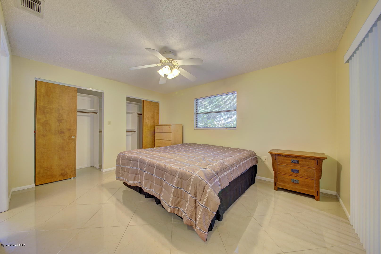 1005 Audubon Road Merritt Island, FL 32953 - Photo 29 of 39 a bedroom with a bed dresser and a window