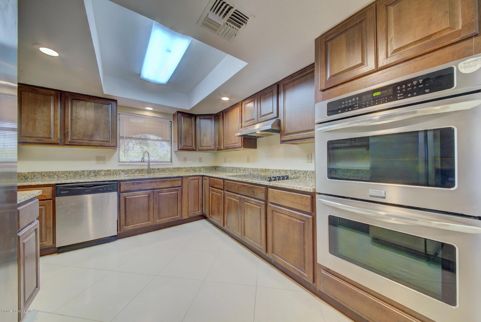 1005 Audubon Road Merritt Island, FL 32953 - Photo 10 of 39 a kitchen with granite countertop stainless steel appliances and wooden cabinets
