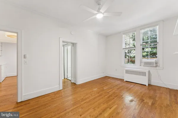 a view of empty room with wooden floor