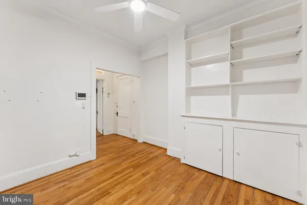 a view of a room with wooden floor and a ceiling fan