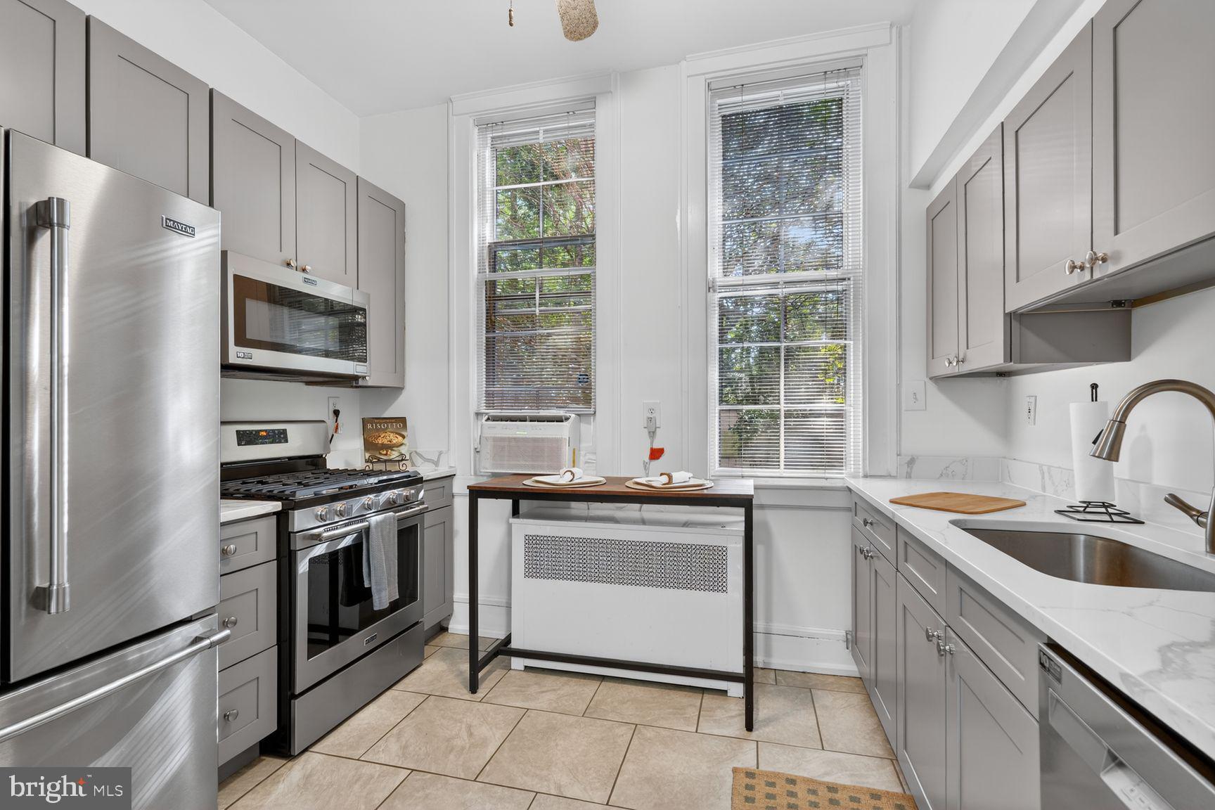 3039 Macomb Street Northwest, Unit 16 Washington, DC 20008 - Photo 7 of 17 a kitchen with stainless steel appliances granite countertop a stove a sink and a refrigerator