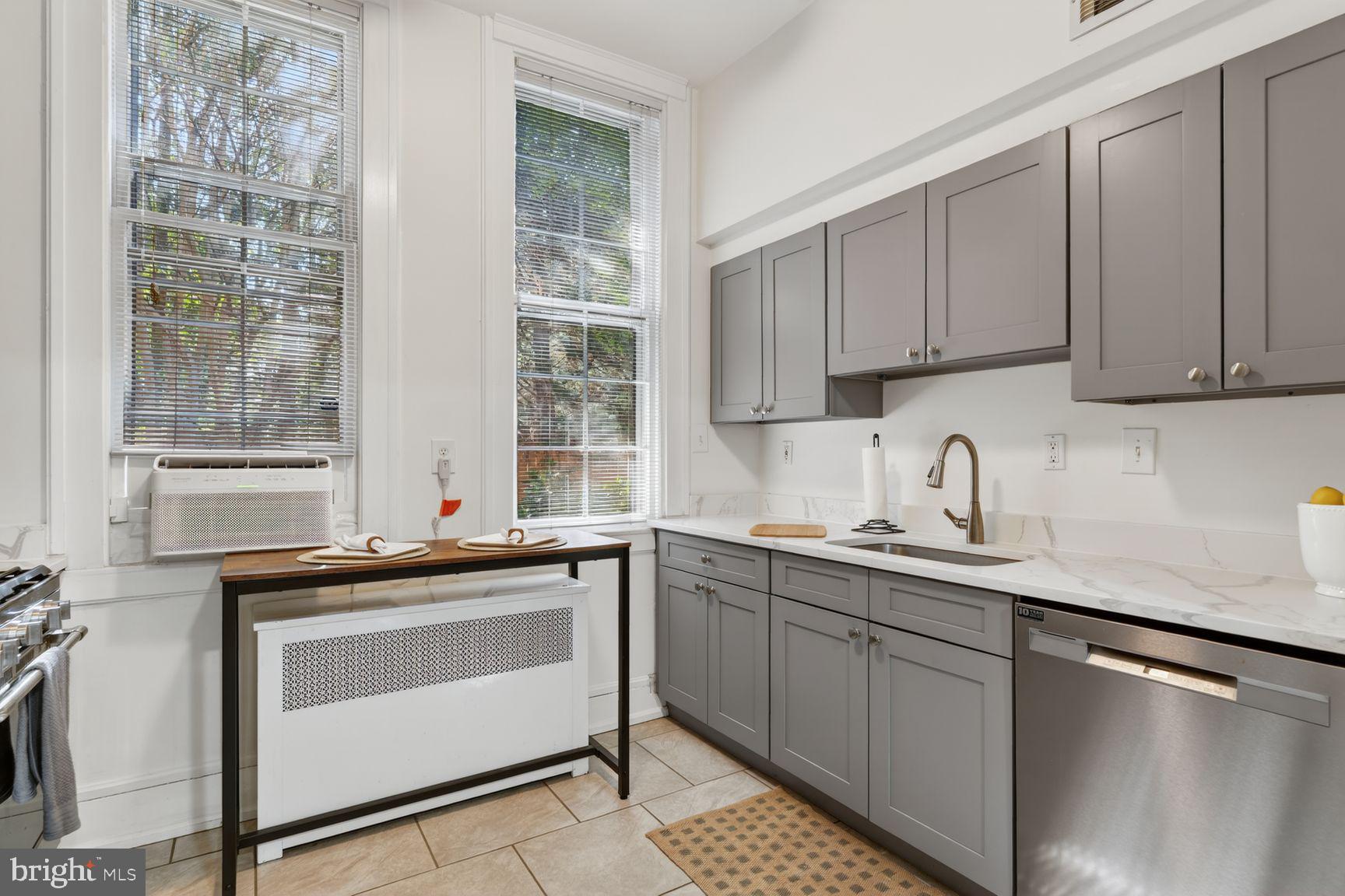 3039 Macomb Street Northwest, Unit 16 Washington, DC 20008 - Photo 10 of 17 a kitchen with stainless steel appliances granite countertop a sink stove and cabinets