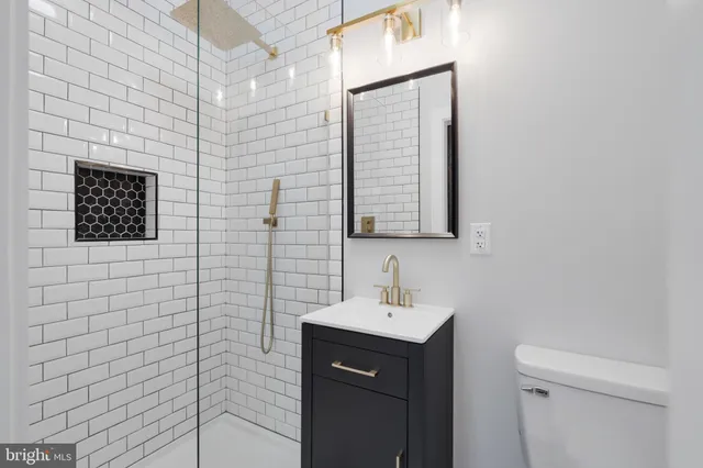 a bathroom with a sink a toilet and mirror