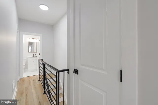 a view of a hallway with wooden floor and staircase