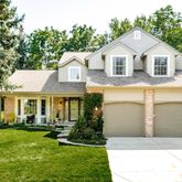 a front view of a house with a yard and trees