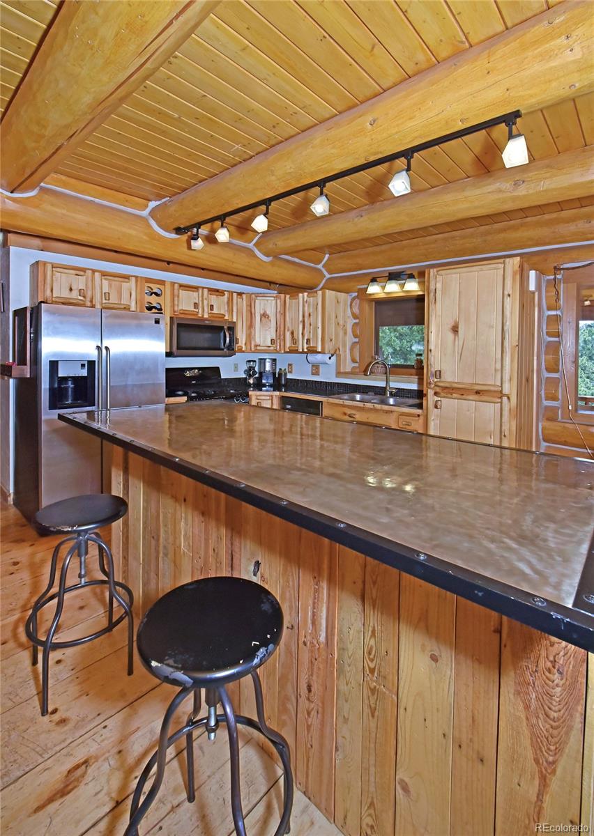 79 Buggy Whip Road Bailey, CO 80421 - Photo 11 of 39 a kitchen with stainless steel appliances granite countertop a sink and wooden floors