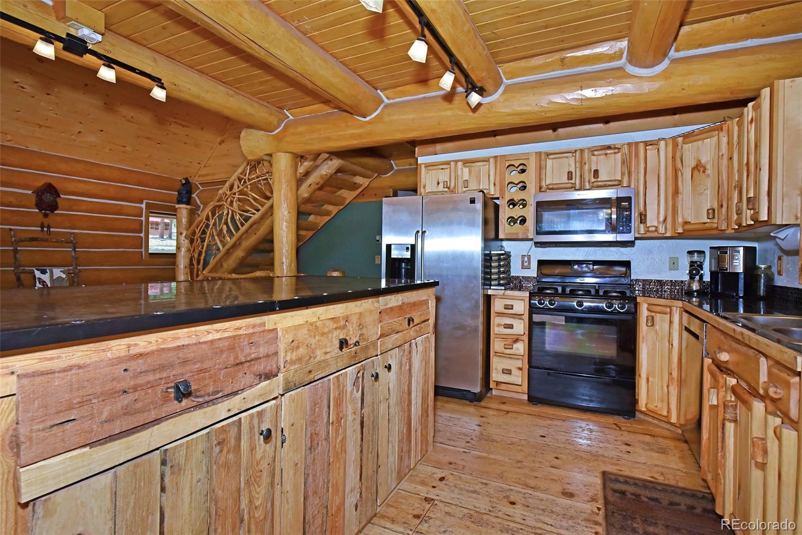 79 Buggy Whip Road Bailey, CO 80421 - Photo 10 of 39 a kitchen with granite countertop a stove cabinets and stainless steel appliances