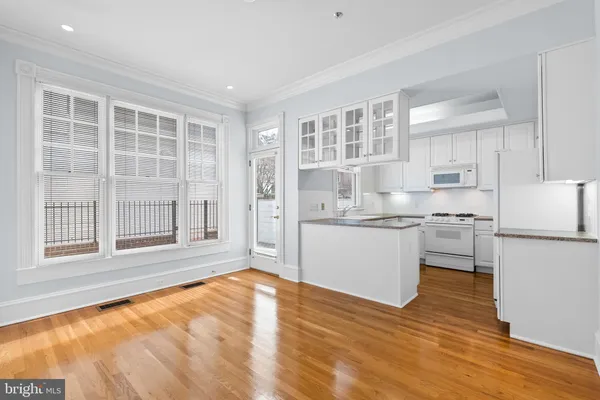 a kitchen with granite countertop a stove a sink and a refrigerator