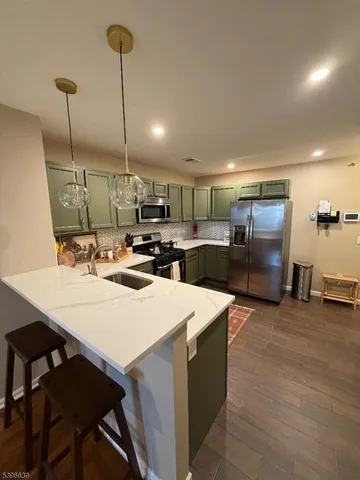 a kitchen with stainless steel appliances kitchen island granite countertop a sink a stove and chairs