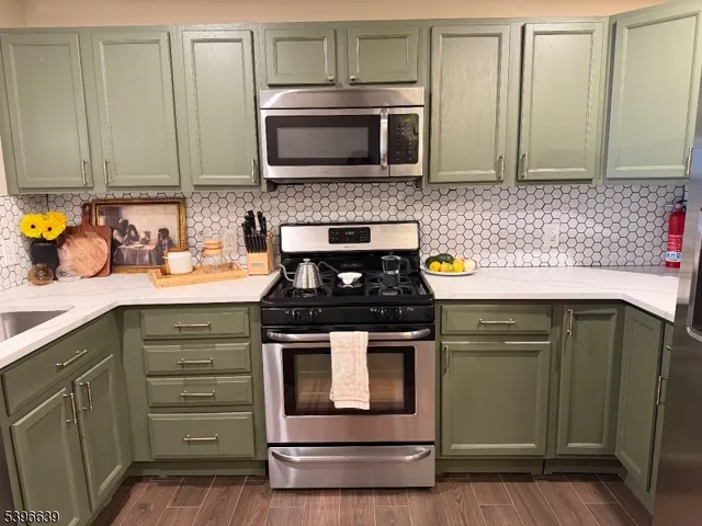 a kitchen with stainless steel appliances granite countertop a stove and a microwave