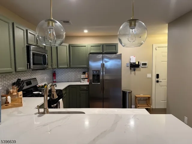 a kitchen with stainless steel appliances a refrigerator a sink a stove and cabinets
