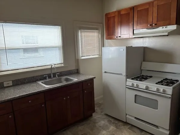 a kitchen with granite countertop cabinets stainless steel appliances a sink and a window