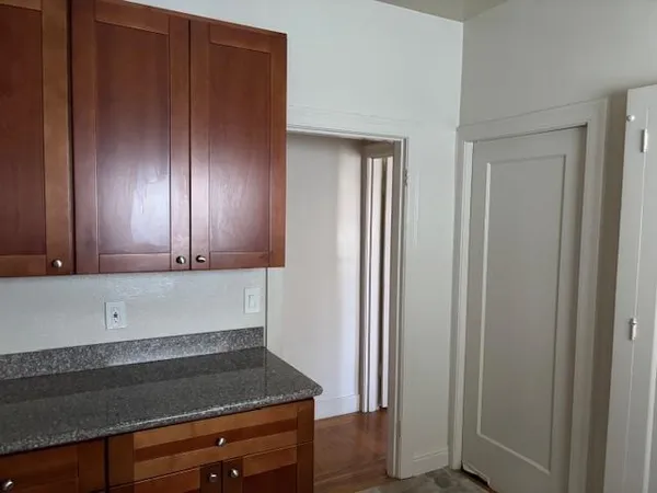 a view of cabinets and utility room with wooden floor